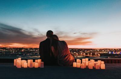 A couple surrounded by cangled watching the sunset - Credit Visit West