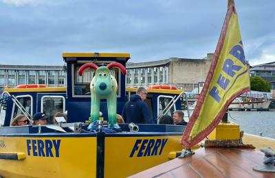 A yellow Bristol Ferry boat with a green gromit on the bow