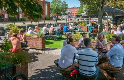 People sitting outdoors under the sun by The Ostrich pub in the Redcliffe area of Bristol - credit Mahtola Eagle
