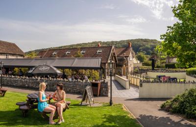 People sitting outside under the sun next to the Railway Inn at Thatchers Cider HQ in Sandford, near Bristol - credit Thatchers