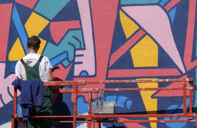 David McMillian painting a mural at Upfest street art festival in Bristol