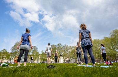 A group of people participating in a yoga class on Queen Square in central Bristol