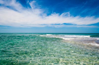 Photo of ocean, beautiful clear water with slight waves breaking on shoal in front of Gasparilla Island at Gasparilla Pass in Charlotte County.