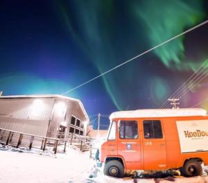an old beer truck in a parking lot with the Aurora overhead