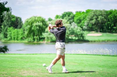 Golfer teeing off at Eagle Valley Golf Course with water feature in the background
