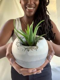 Owner of Awkward Auntie holds cement succulent planter