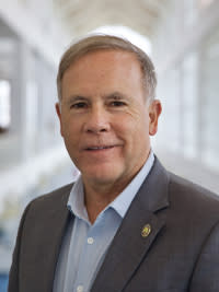 Business man in blue button down and gray suit coat
