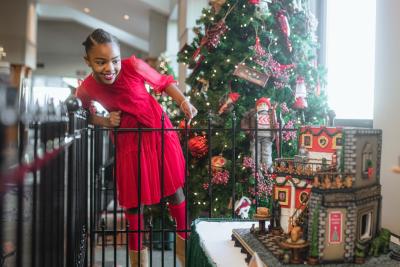 Girl smiling looking down at gingerbread house display at Omni Grove Park Inn