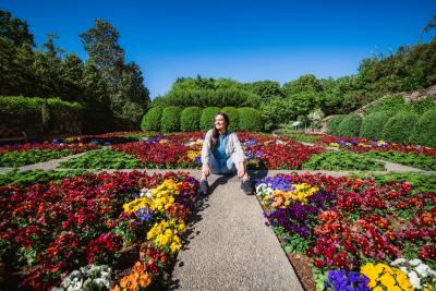 Girl sitting in a middle of garden designed like a quilt at the North Carolina Arboretum