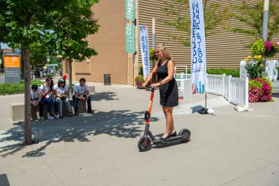 Woman riding Spin scooter outside of Greater Columbus Convention Center