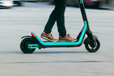 Man riding Veo scooter down city street