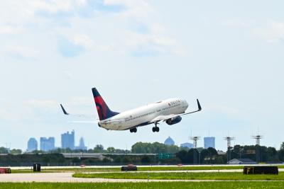 Delta Air Lines plane taking off from John Glenn International Airport on sunny afternoon