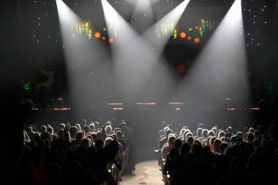 Spotlights shine on a large audience at Peabody Auditorium