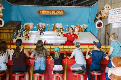 A staff member running Flushing Meadows for a crowd at Funland in Rehoboth Beach, Delaware.