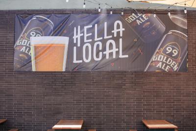 Sign hanging up reads, "Hella Local" and shows picture of beer glass.