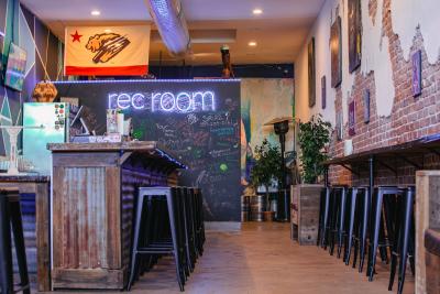 Interior of 411 Rec Room with bar, chairs and art on the walls.
