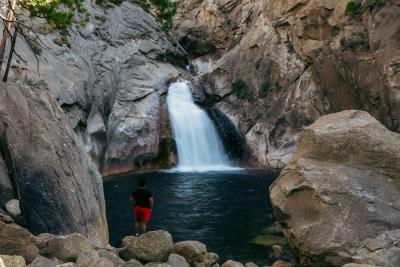 Man faces rushing waterfall in Kings Canyon National Park