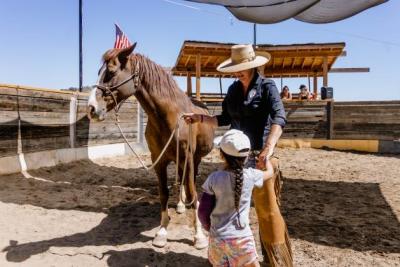 Woman and child pet horse on ranch