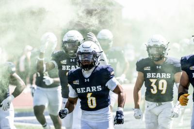 UNC Bears football players entering the field before the start of the game in a cloud of smoke for visual effect