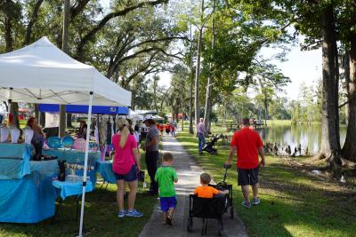 Family walking along the shore of Lake Alice Park during the Fall Festival