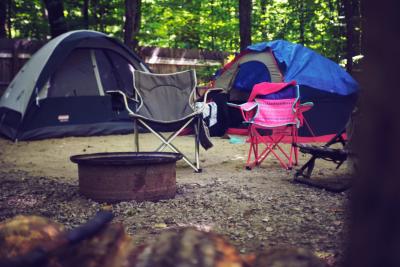 Campsite with two tents, chairs, and fire ring