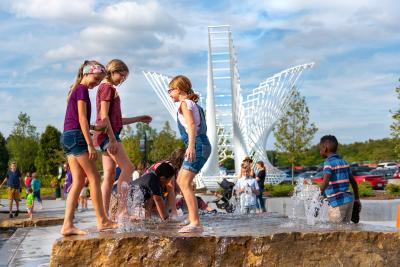 kids playing in the kids canal water feature at promenade park in fort wayne