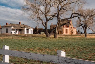 large brick building next to small white house
