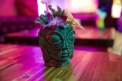 Tiki themed cocktail shot in colorful light.