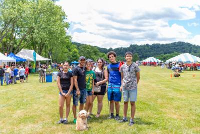 Group of people having fun at the spring fiesta with their small dog