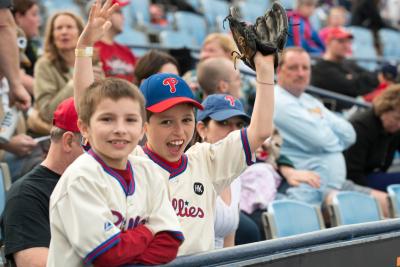 Children cheering with smiles at the baseball game