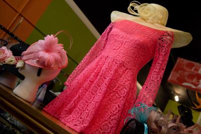 A pink dress on a stand with a Derby-style women's hat.