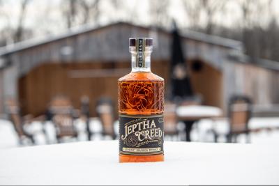 A bottle of Jeptha Creed bourbon in the snow.