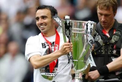 Leon Britton holding a large silver cup trophy