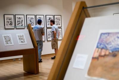 Close up of artwork with patrons in background at the Billy Ireland Cartoon Museum