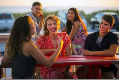 Millennials laughing and dining at sunset