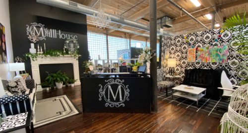 MillHouse McKinney lobby with logo on a podium and comfortable seating with black and white decor