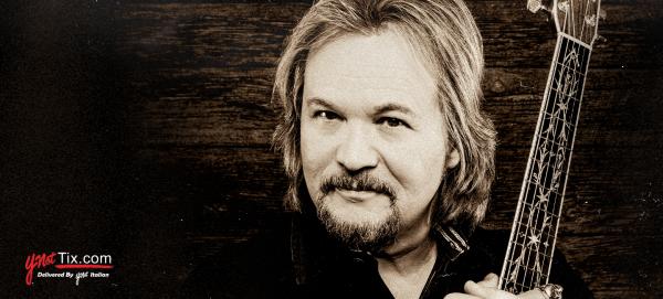 Travis Tritt holding a guitar