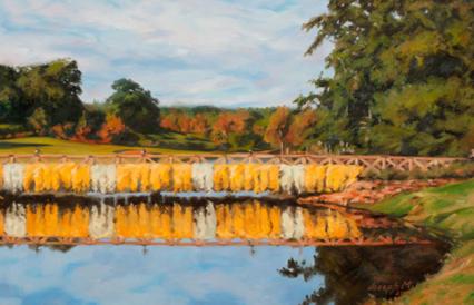 Cascading yellow and white mums over a bridge with reflection in the water below