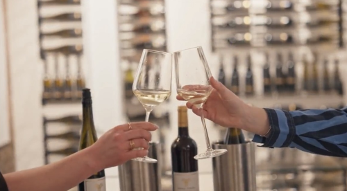 two people cheering wine glasses