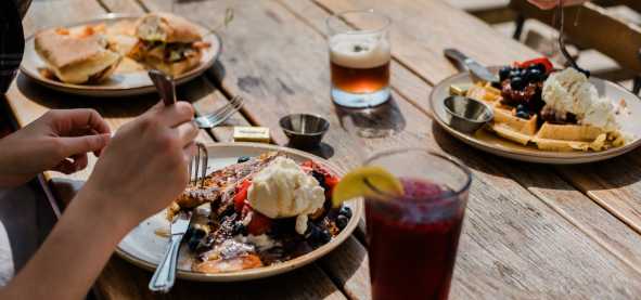 A table of delicious food on the outdoor patio at Root Cellar Cafe in Downtown San Marcos, Texas