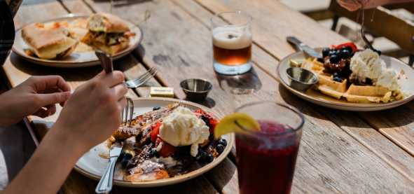 A table of delicious food on the outdoor patio at Root Cellar Cafe in Downtown San Marcos, Texas