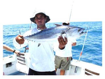 Fisherman showing off a freshly-caught bonita