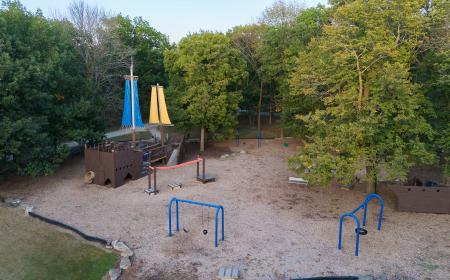 Top down drone shot of pirate ship play structure and swing set