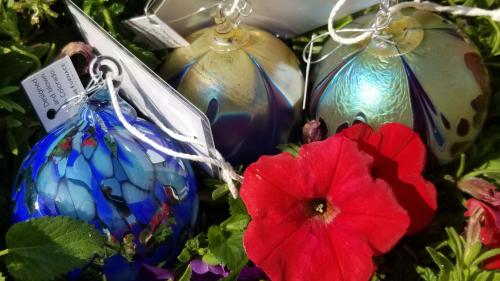 A decorative red flower and three hand blown glass orbs part of the September scavenger hunt in Golden CO 2025 by @shinyspheresearch
