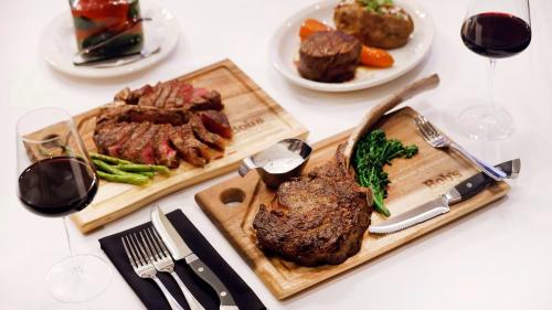 Two wooden trays of cooked steaks at Bob's Steak & Chophouse