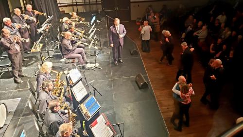 Big band on stage with couples dancing