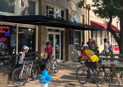 Cyclists gather in front of Cadence Cyclery shop