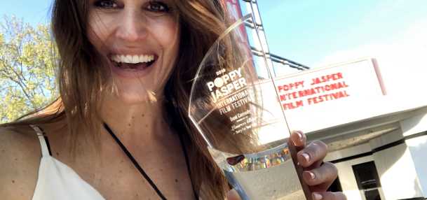 Poppy Jasper happy person holding award