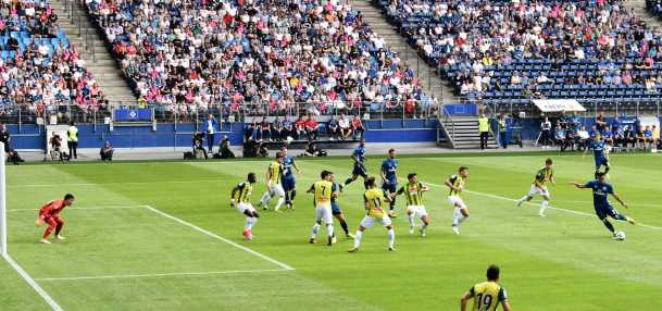 soccer players on the field with stadium audience in the background