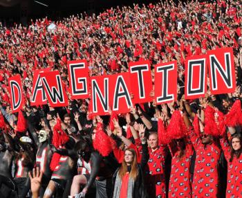 Fans holding signs that say Dawg Nation at a UGA football game